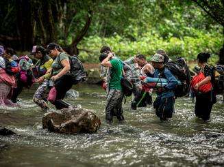 Migrants cross a river in the Darien Gap 