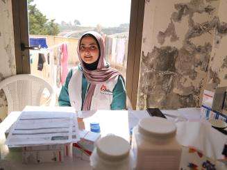 An MSF staff member through the window of a shelter for IDPs in Saida, South Lebanon