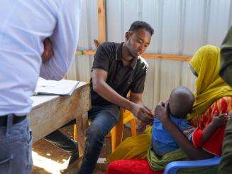 Health care worker measuring arm circumference of a child in Baidoa, Somalia