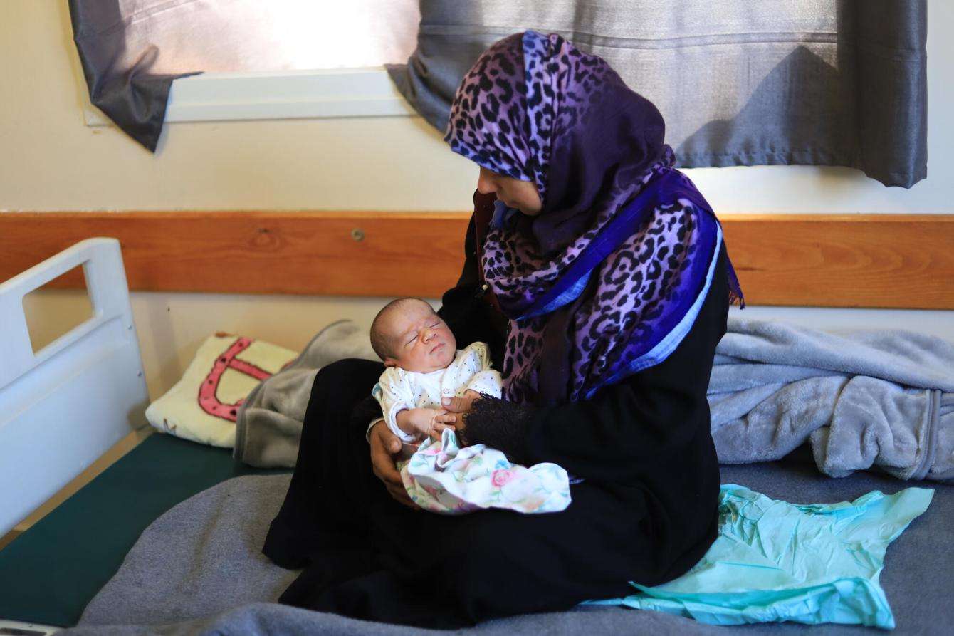 A mother cradles her newborn in Nasser Hospital, Gaza.