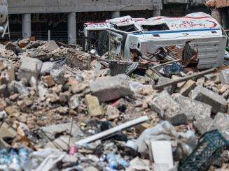 Rubble from war and violence and a flipped over ambulance in Mosul, Iraq