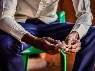 A diabetic refugee from Somalia sits in Dagahaley camp, Kenya, holding his insulin.